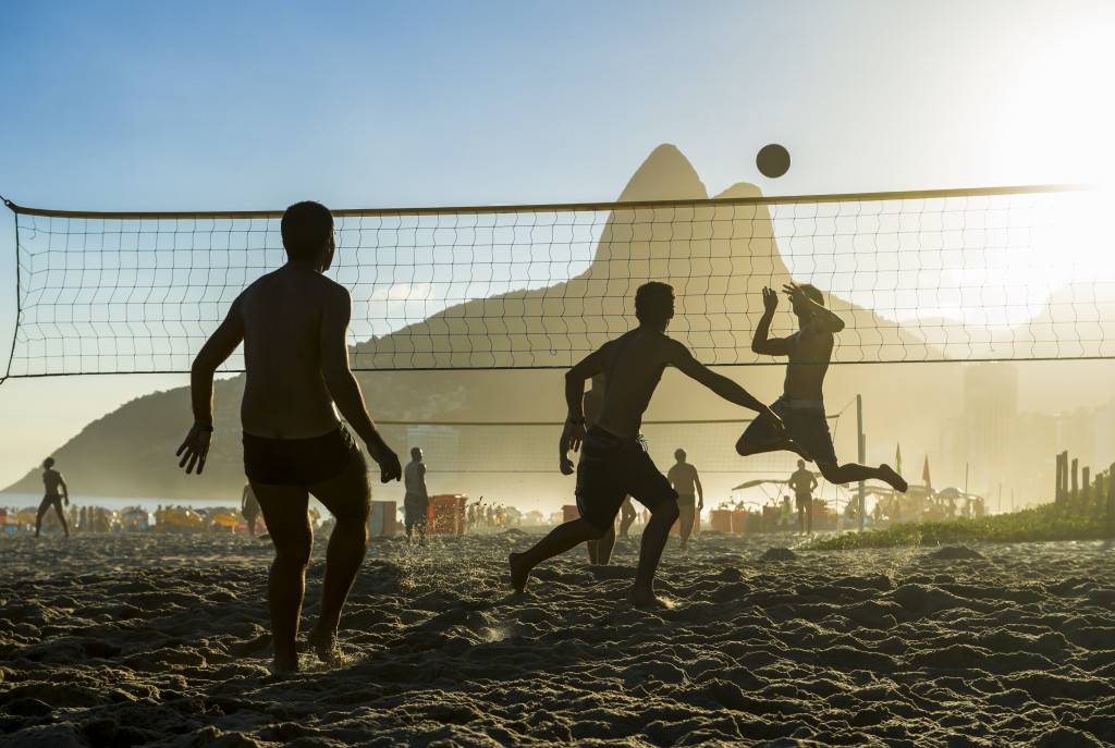 group of men playing beach volleyball